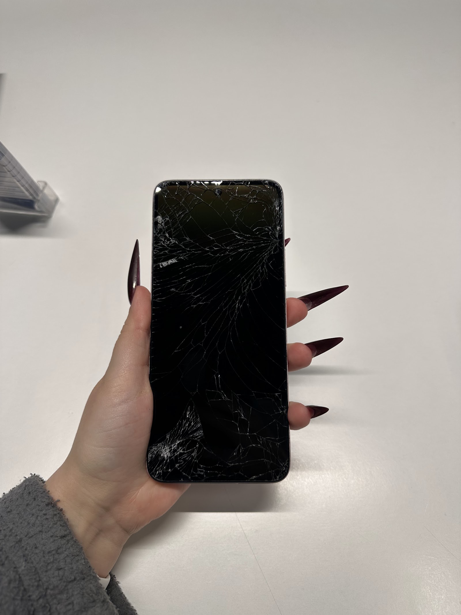 Mõranenud ekraaniga Xiaomi Redmi telefon käes SkyMobile töökojas